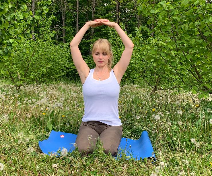 Kundalini Shakti vježba na plavoj prostirci u zelenilu