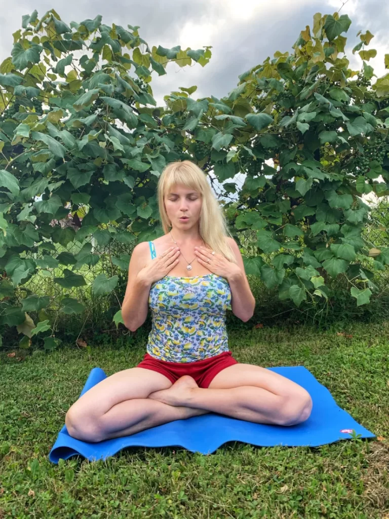 Meditacija za suosjećajnost: sjedi u easy pose, palčevi su ispod pazuha, dlanovi su na prsima