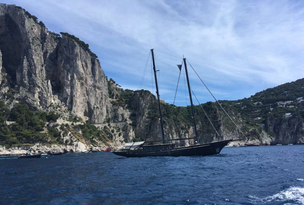 Jedrilica plovi morem uz stjenovitu uvalu, simbolizira put otkrivanja životne svrhe